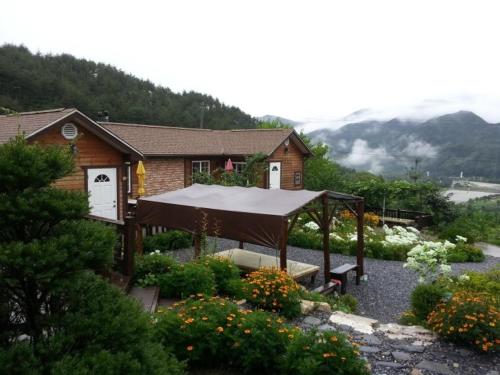 a house with a covering in front of a garden at Oraview Pension in Jeongseon