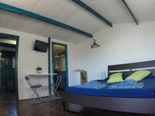 a bedroom with a bed with blue sheets and yellow pillows at Cabaña Granitas in Gran Tarajal