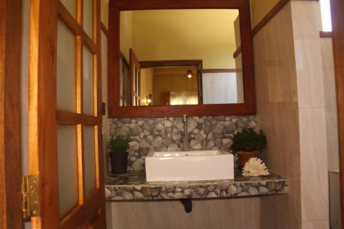 a bathroom with a sink and a mirror at Lily Bank Cottage in Nuwara Eliya