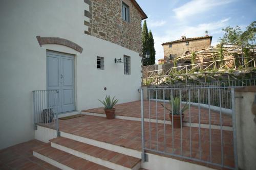 a balcony with a blue door and potted plants at La Dispensa-bio agriturismo in Lamporecchio