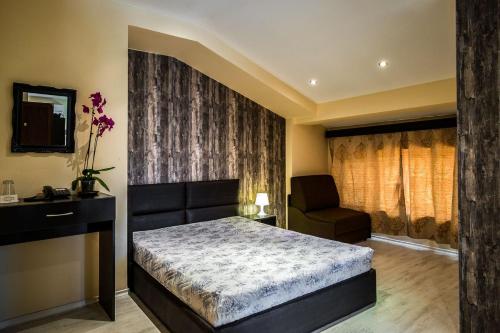 a bedroom with a bed and a chair at Hi-Life Family Hotel in Novi Iskŭr