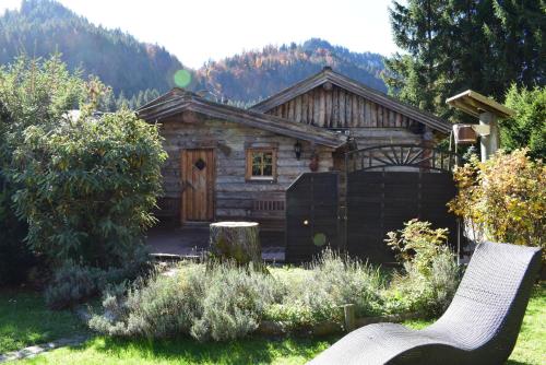 a log cabin with a bench in front of it at Sonnenbichl Hotel am Rotfischbach in Fischen