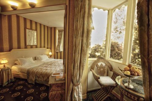 a hotel room with a bed and a window at Belle Isle Sur Risle - Chateau Hotel & Spa in Pont-Audemer