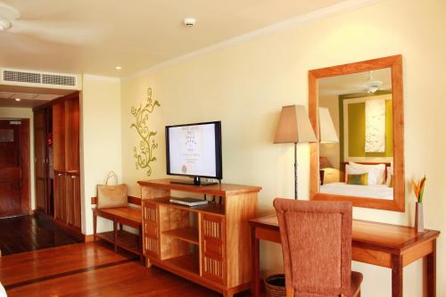 Zimmer mit einem Schreibtisch, einem TV und einem Schlafzimmer. in der Unterkunft The Emerald Cove Koh Chang in Ko Chang
