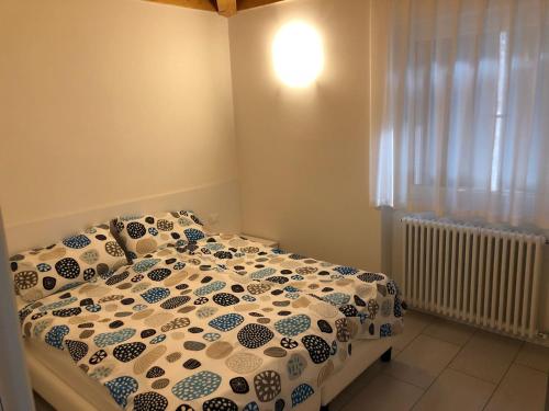 a bedroom with a bed with a comforter and a window at Casa Magosta in Malcesine