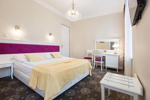 a bedroom with a large bed and a desk at Dwór Hetman in Jarosław