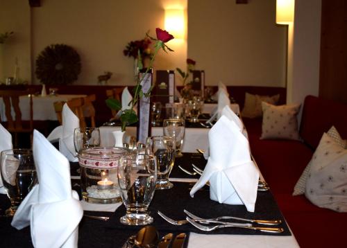 a table with glasses and napkins on top at Sonnenbichl Hotel am Rotfischbach in Fischen