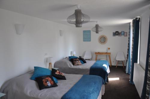 1 Schlafzimmer mit 2 Betten mit blauer und grauer Bettwäsche in der Unterkunft Le Florentin in Florentin-la-Capelle