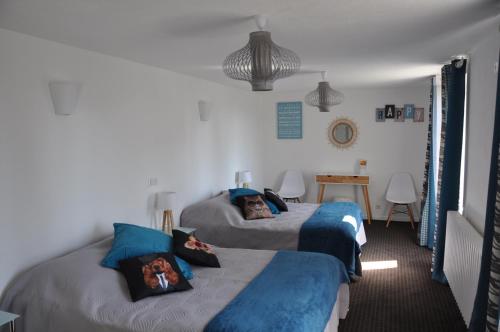 a bedroom with two beds with blue and gray sheets at Le Florentin in Florentin-la-Capelle