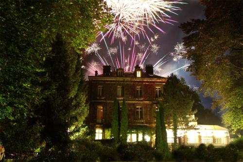 a fireworks display over a house with a building at Belle Isle Sur Risle - Chateau Hotel & Spa in Pont-Audemer