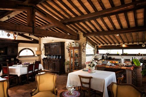a dining room with two tables and a kitchen at Antico Podere Vitiano - Luxury country house in Castel Viscardo