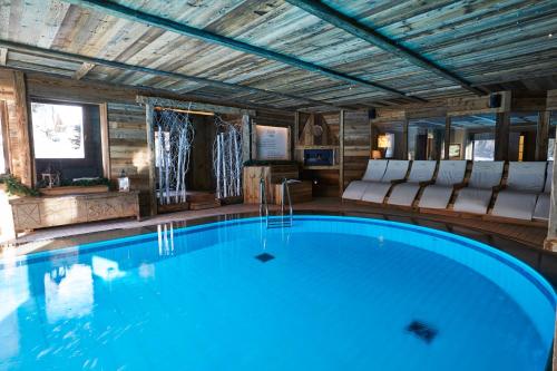 a large swimming pool in a room with a room at Gran Baita Hotel & Wellness in Courmayeur