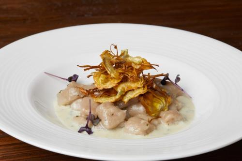 a white plate of food on a wooden table at Gran Baita Hotel & Wellness in Courmayeur
