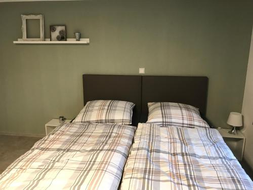 a bedroom with two beds with plaid sheets at Das kleine Schwarze in Parsau