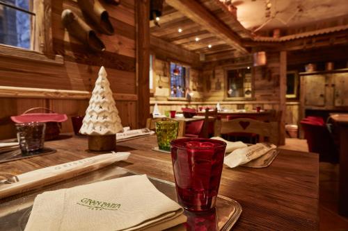 a wooden table with a red glass on top of it at Gran Baita Hotel & Wellness in Courmayeur