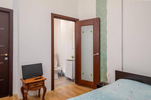 1 dormitorio con 1 cama y mesa con TV en M Central Apartments, en Cluj-Napoca