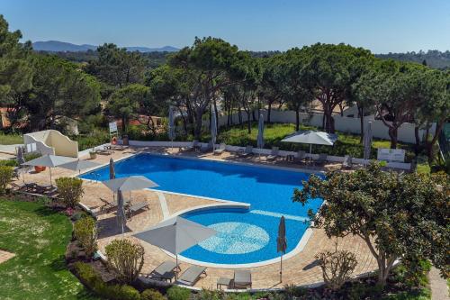 an overhead view of a swimming pool with umbrellas at Apartamentos Valverde - Quinta do Lago in Quinta do Lago
