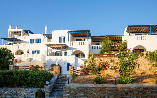 a row of white buildings with stairs in front at Villa Maniati Studios in ayios Petros