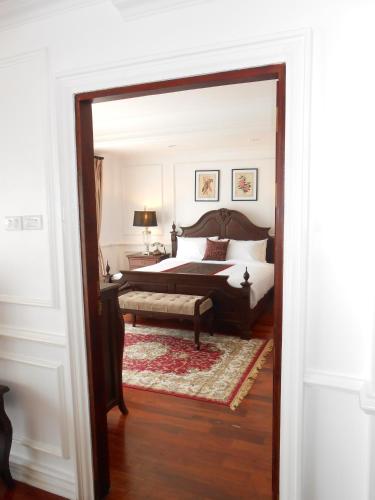 a bedroom with a king sized bed and a table at Dhavara Boutique Hotel in Vientiane