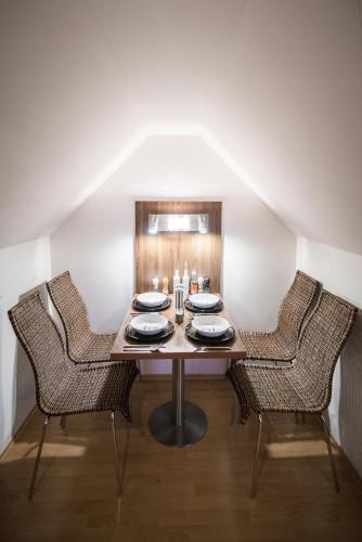a table with three chairs and a table with plates and candles at Horský apartmán Špindlerův Mlýn in Krausovy Boudy