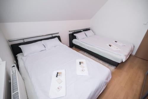 two beds in a hotel room with white sheets at Horský apartmán Špindlerův Mlýn in Krausovy Boudy