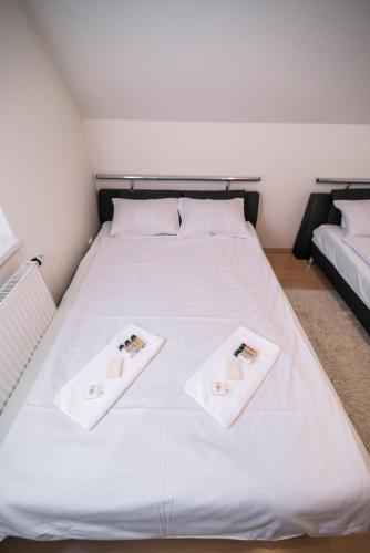 a large white bed with two white towels on it at Horský apartmán Špindlerův Mlýn in Krausovy Boudy