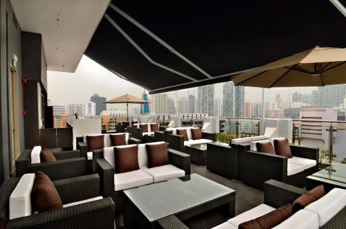 a rooftop bar with chairs and tables and a city skyline at The Seacare Hotel in Singapore