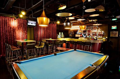 a pool table in a bar with chairs and a bar at The Seacare Hotel in Singapore