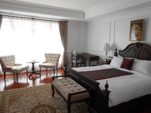 a bedroom with a bed and a table and chairs at Dhavara Boutique Hotel in Vientiane