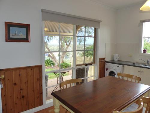 a kitchen with a wooden table and a table and chairs at Glenbar cottage Yelta in Mildura