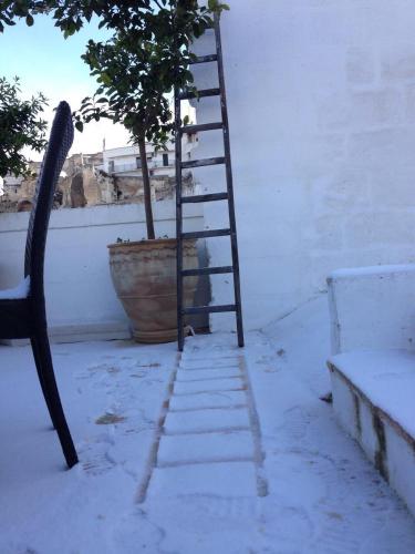 a ladder and a potted tree next to a building at Albergo Diffuso Il Casale in Ginosa