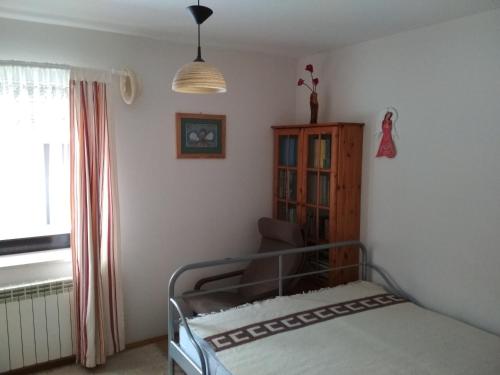 ein Schlafzimmer mit einem Bett, einem Stuhl und einem Fenster in der Unterkunft Apartament u Michała in Krynica-Zdrój