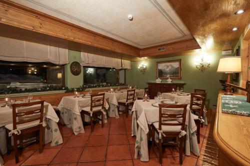 a dining room with tables and chairs with white table cloth at Gran Baita Hotel & Wellness in Courmayeur
