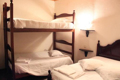 two bunk beds in a room with white sheets at Mikotania in Covilhã