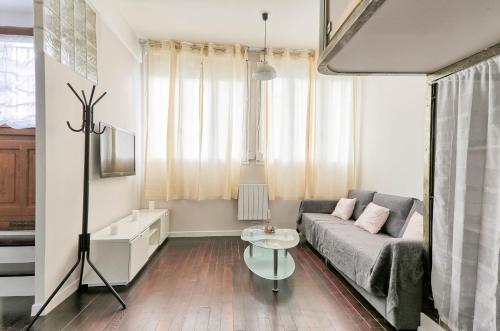 a living room with a couch and a table at Le Marnois-Centre Ville in Noisy-le-Grand