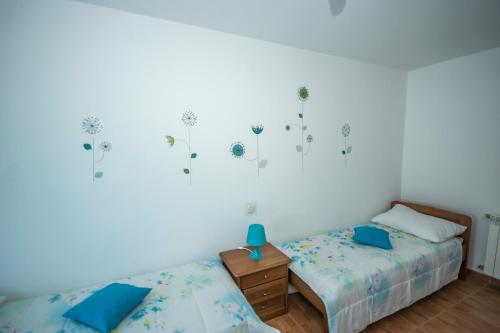 a bedroom with two beds and a table with a lamp at Apartment Ana in Pula