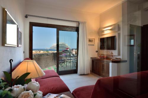 a living room with a red couch and a view of the ocean at Residence L'Ea di Lavru - Appartamenti Mono-Bilo-Trilocali in Porto San Paolo