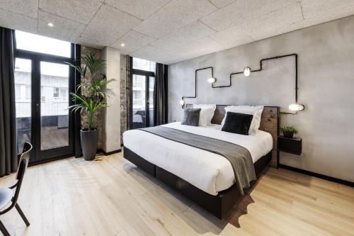 een slaapkamer met een groot bed en een groot raam bij Upstairs Hotel in Oostende