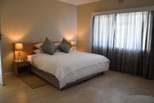 a bedroom with a bed and a large window at 34onlincoln Guesthouse in Bellville