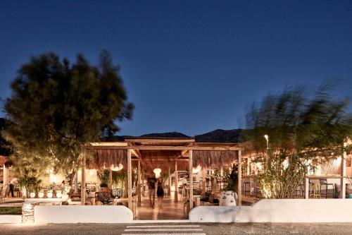a wooden house with lights on it at night at Dionysos Seaside Resort Ios in Mylopotas