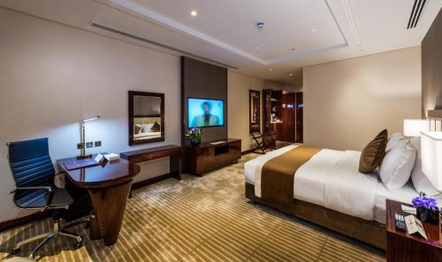 a hotel room with a bed and a desk and a television at Braira Al Wezarat in Riyadh