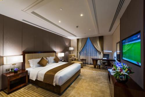 a hotel room with a bed and a flat screen tv at Braira Al Wezarat in Riyadh