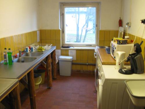 eine kleine Küche mit einem Waschbecken und einem Fenster in der Unterkunft Ferienheim Mosbach in Wutha-Farnroda