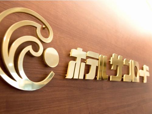 a gold sign that says give on a wall at Hotel Sun Road in Amakusa