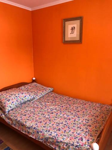 a bed in a bedroom with an orange wall at BaletyuKatany in Białka Tatrzanska