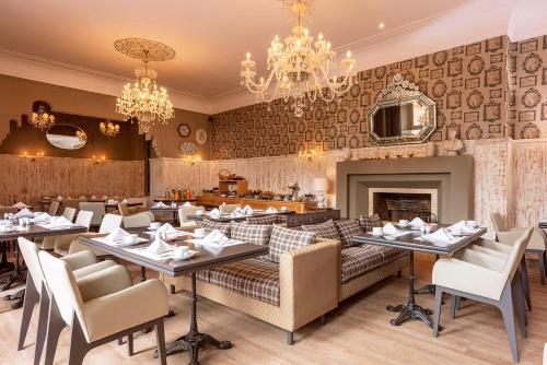a restaurant with tables and chairs and a fireplace at Tigmiza Boutique Hotel & Spa in Marrakech