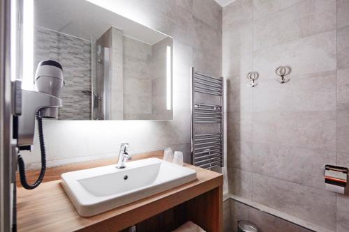 a bathroom with a sink and a mirror at Kyriad Clermont Ferrand Nord - Riom in Riom