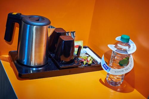 a coffee pot and a bottle of water on a counter at Kyriad Clermont Ferrand Nord - Riom in Riom