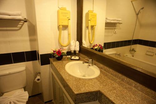 a bathroom with a sink and a mirror and a toilet at Royal Panerai Hotel Chiangmai in Chiang Mai