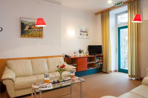 a living room with a couch and a table at Haus Mobene - Hotel Garni in Graz